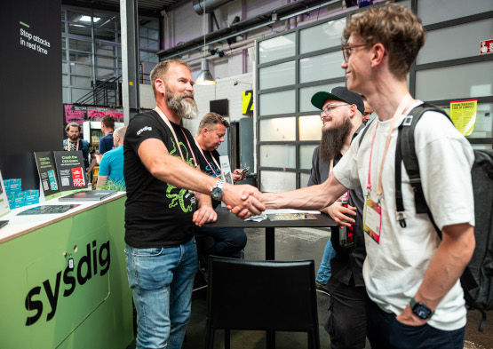 Two men shaking hands on a booth